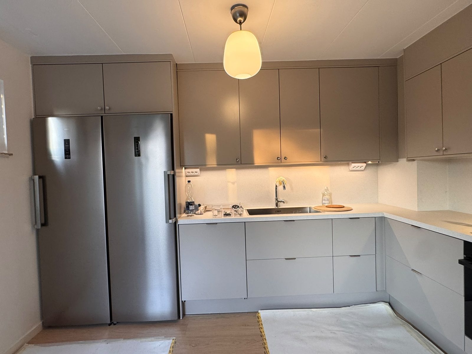 Samma kök efter renoveringen, med nya grå skåp
